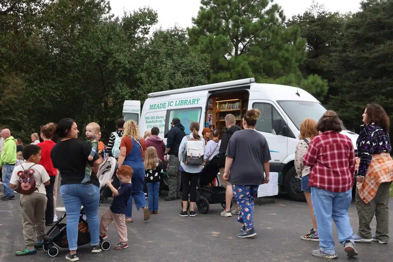 A group of patrons gathers arouns the bookmobile. 