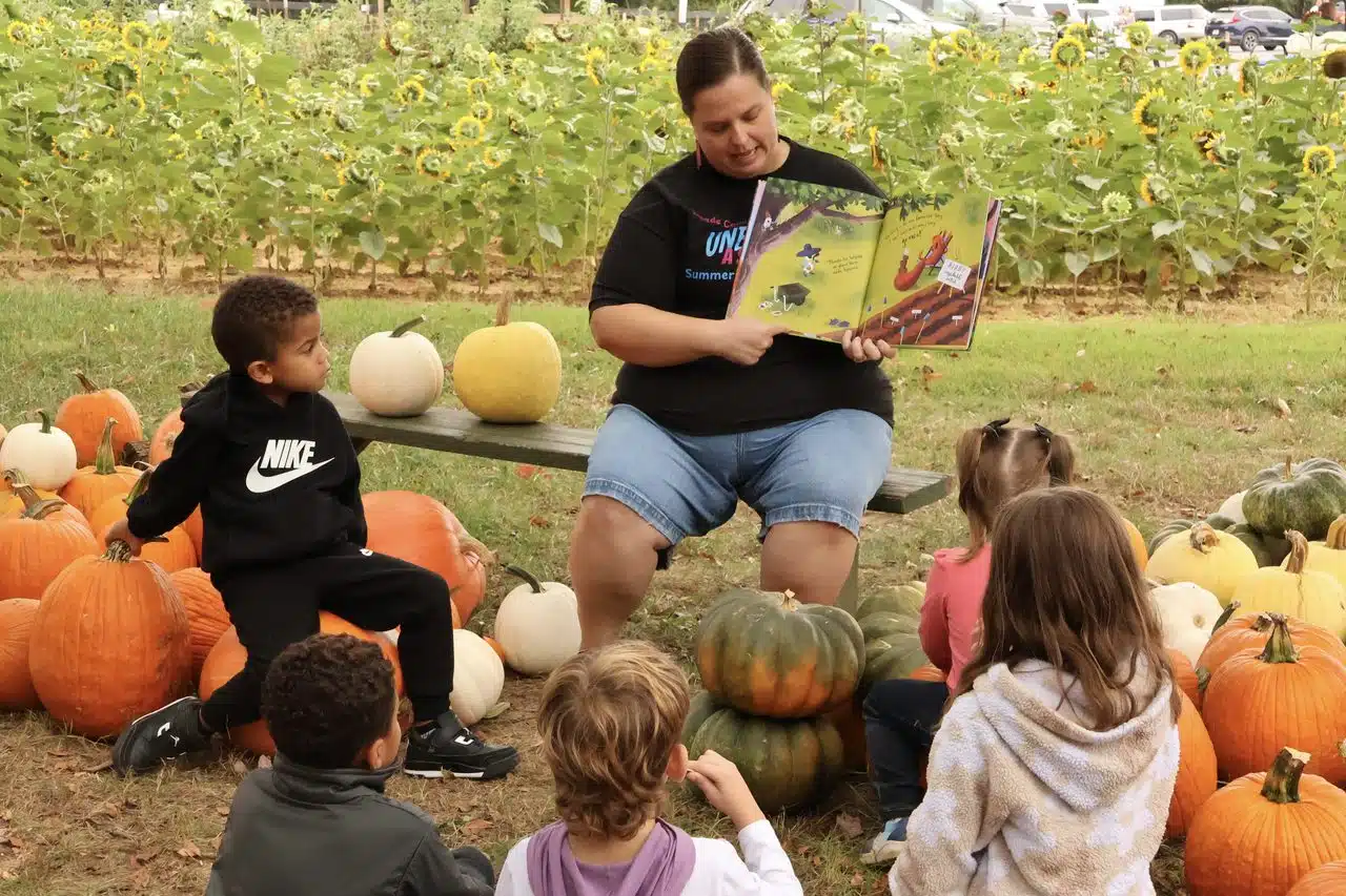 A group of children gather around to hear a story. 