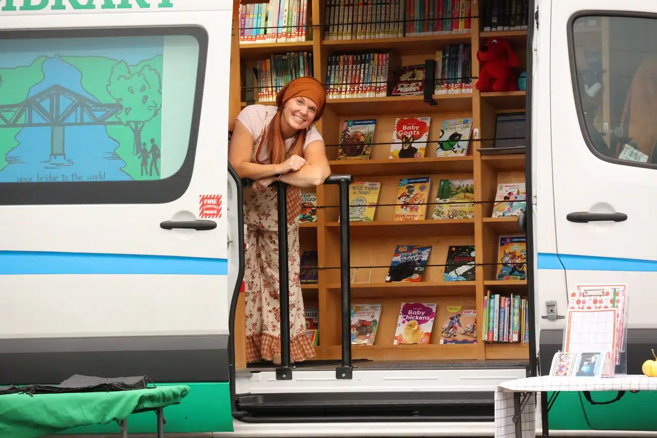 The bookmobile with the door open displaying books. 