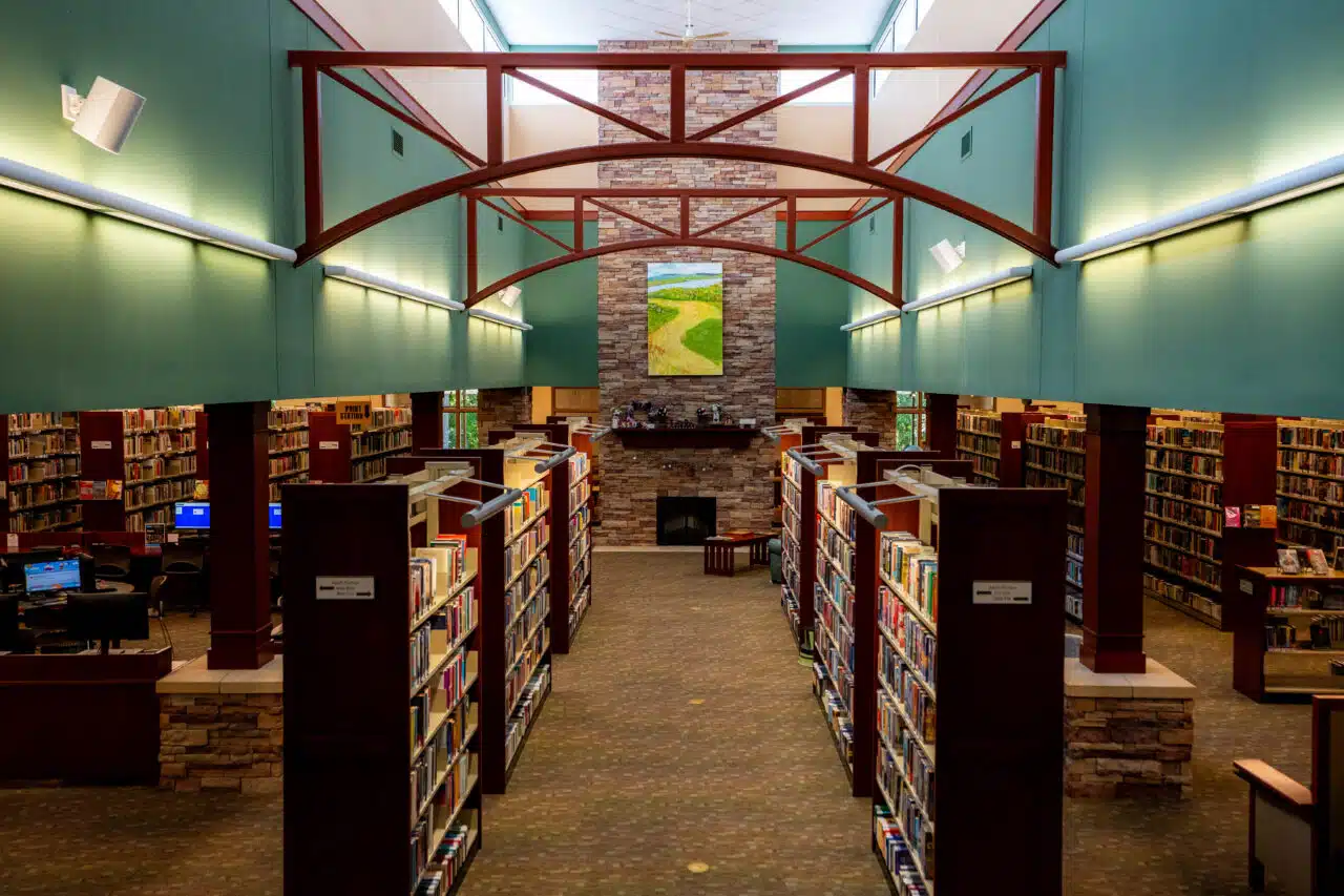 The interior of the library showing books and a fireplace.